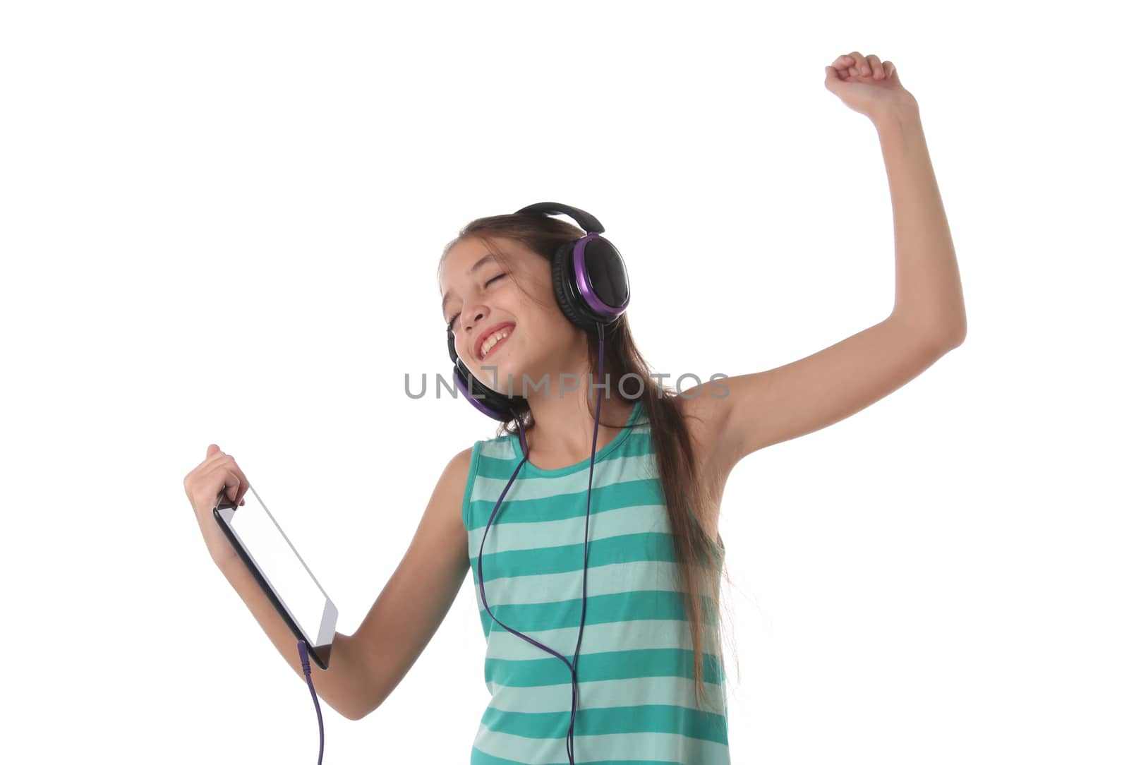 Beautiful pre-teen girl dancing with a tablet and headphones by Erdosain