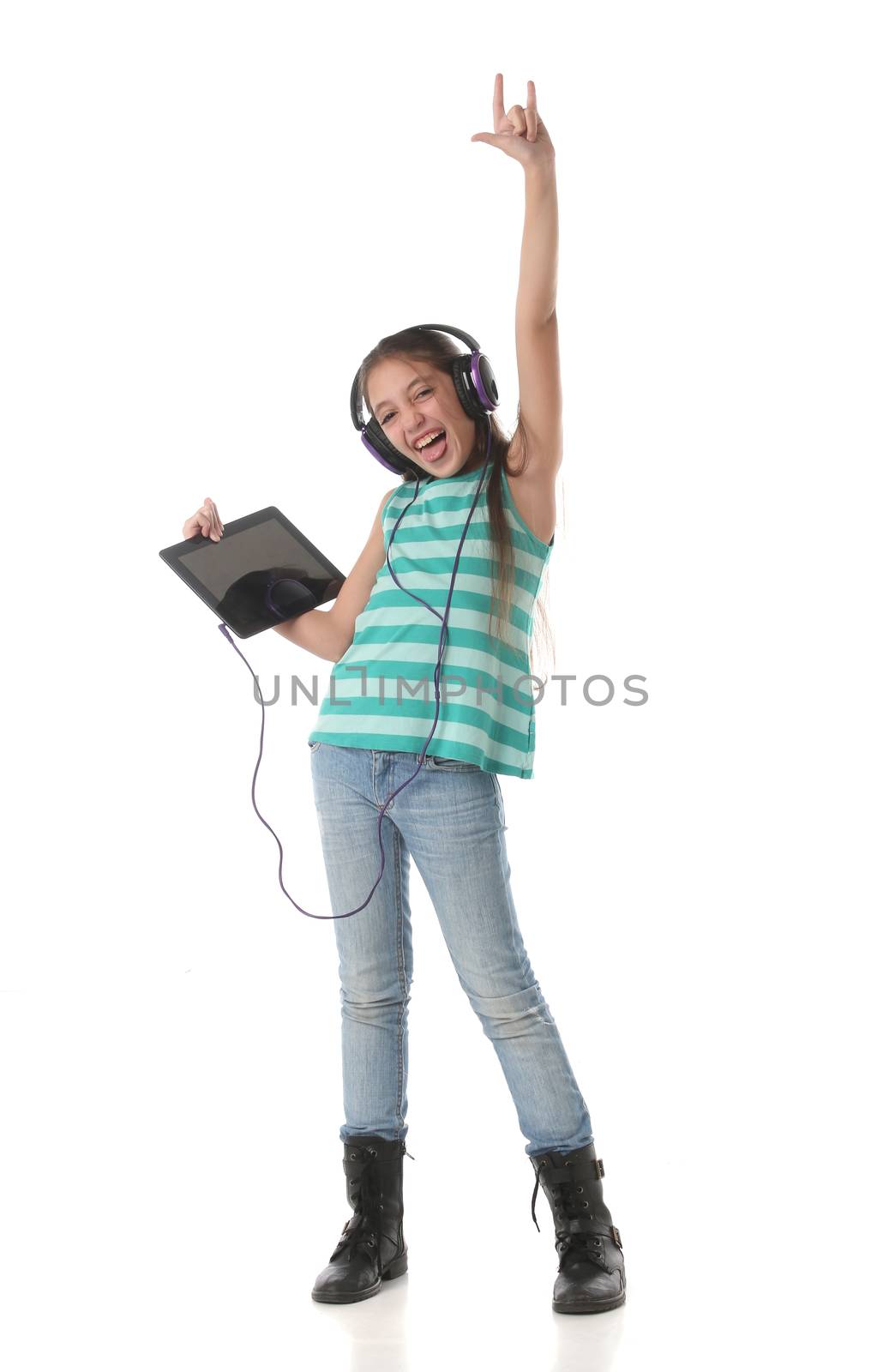 Beautiful pre-teen girl dancing and going crazy using a tablet computer and headphones