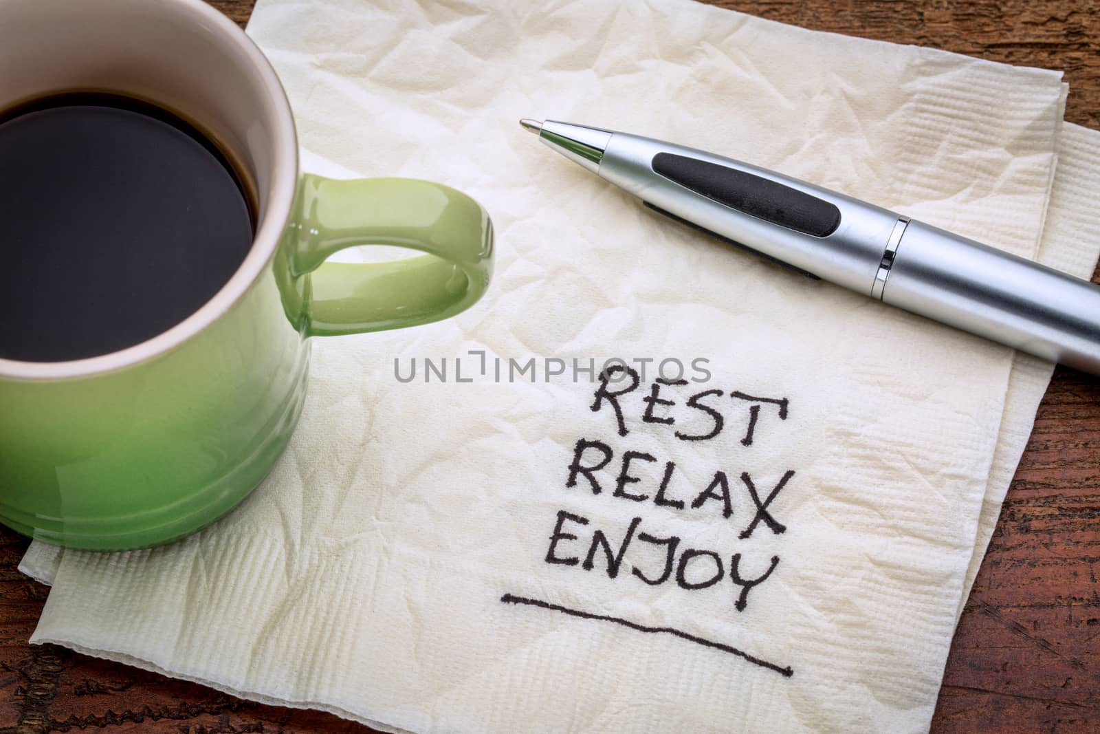 rest, relax, enjoy - handwriting on a napkin with a cup of coffee