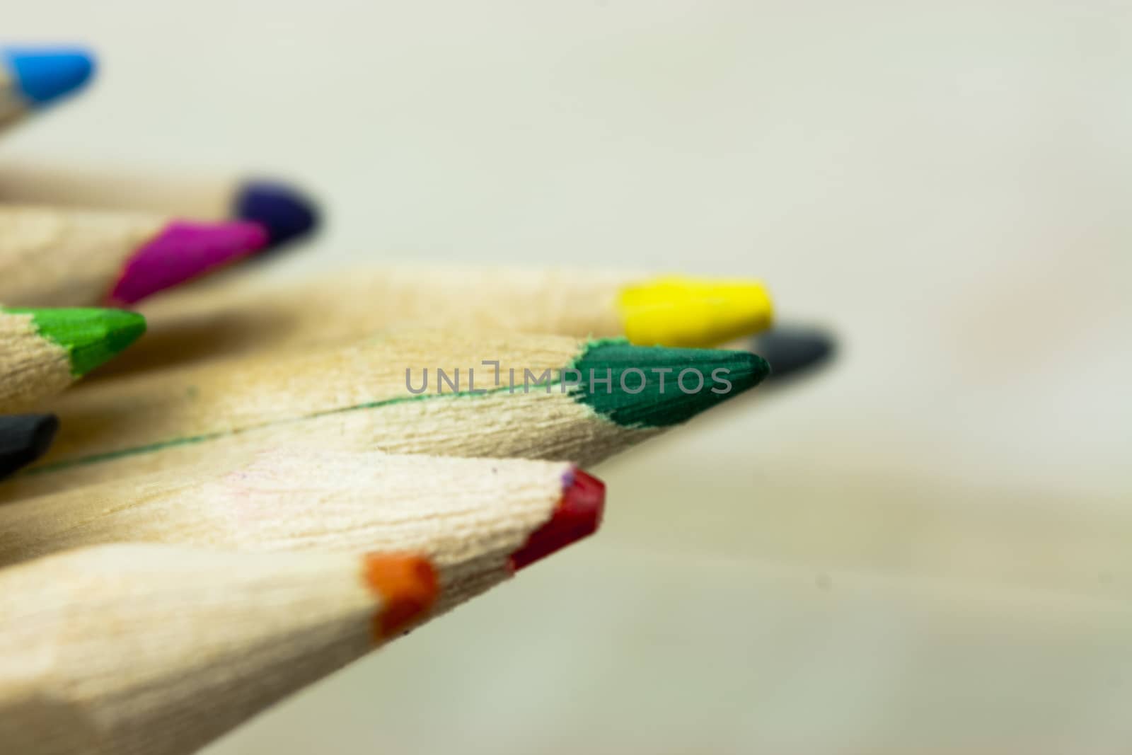 Close f of coloured pencils against a wooden background