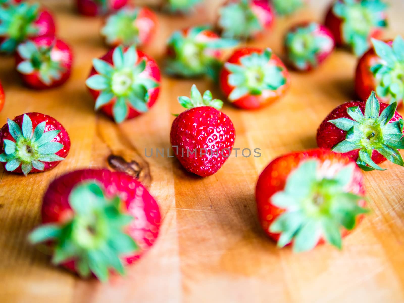Arranged strawberries on a wooden board by weruskak