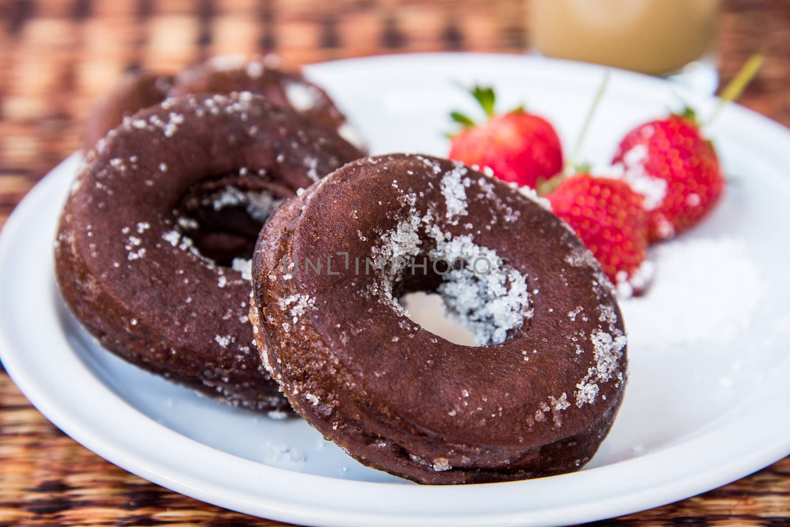 Sugar chocolate donuts and fresh strawberries and ice coffee