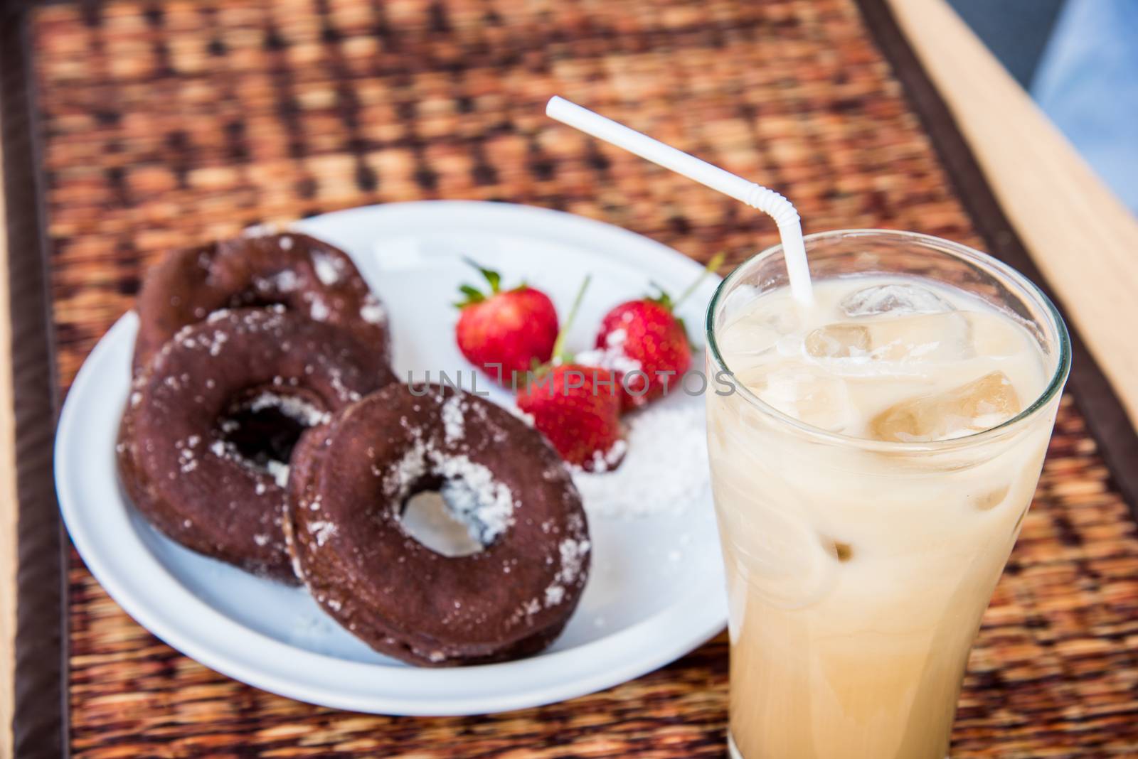 Sugar chocolate donuts and fresh strawberries and ice coffee