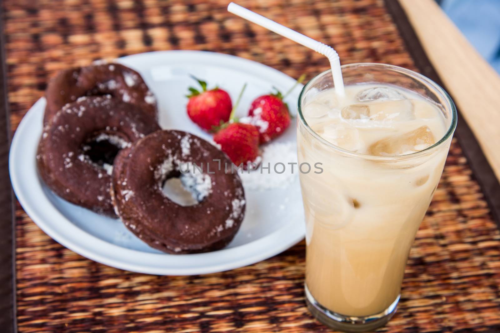 Sugar chocolate donuts and fresh strawberries and ice coffee