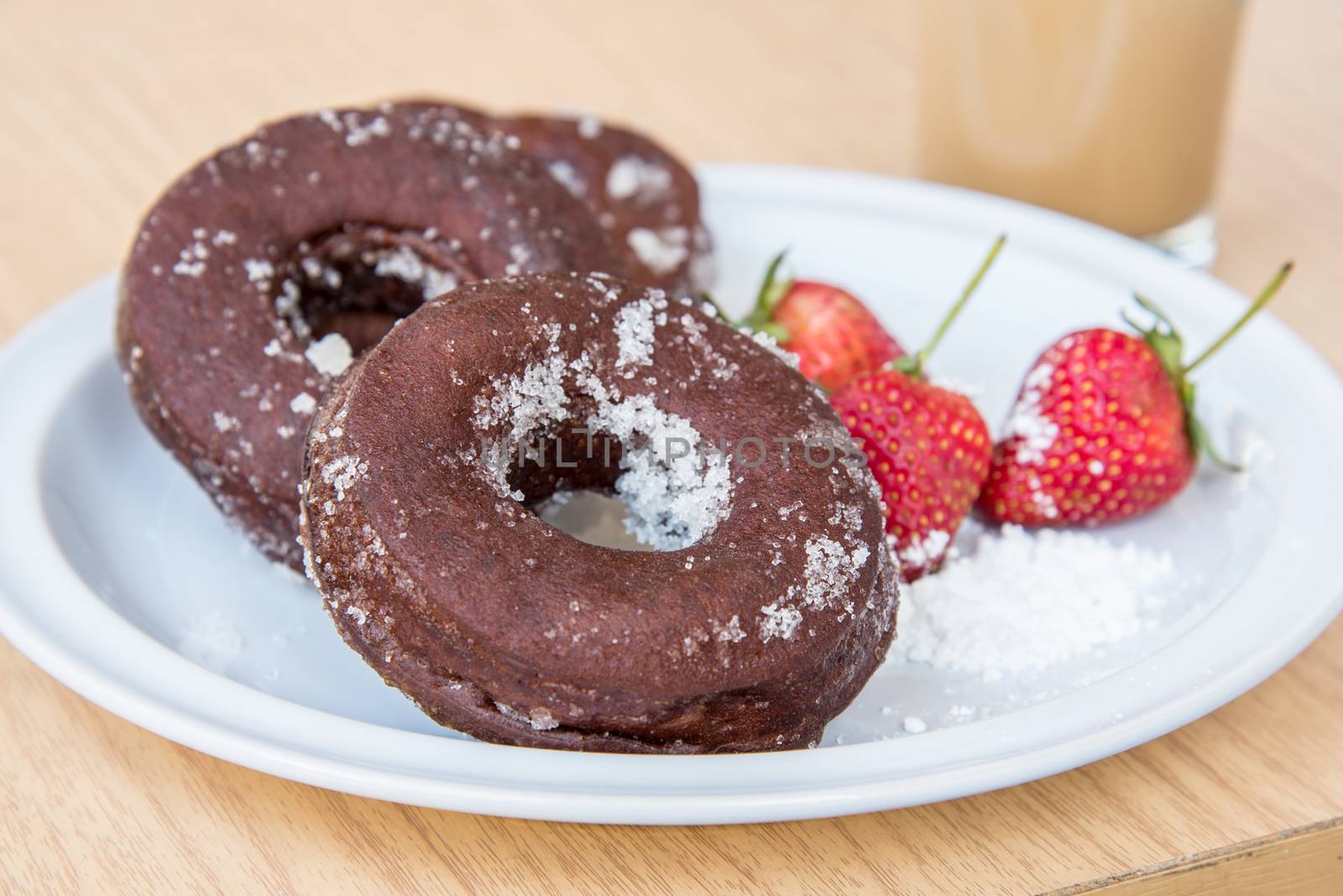 Sugar chocolate donuts and fresh strawberries and ice coffee