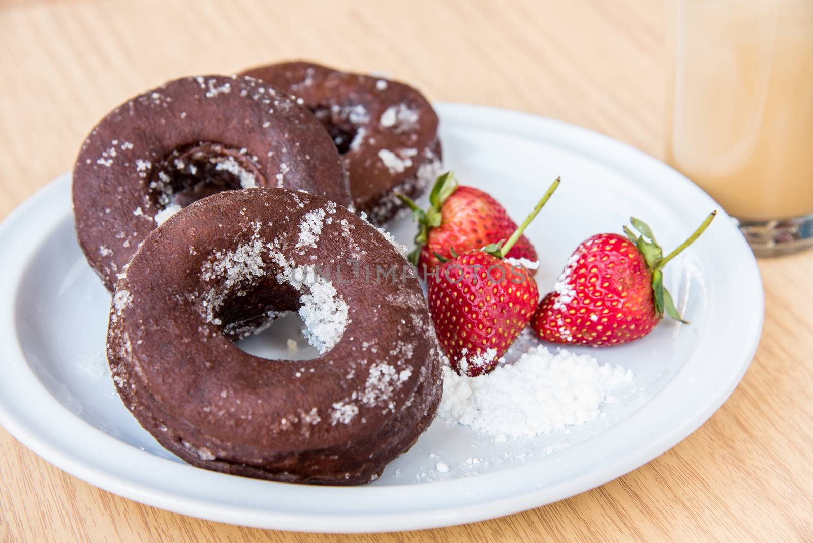 Sugar chocolate donuts and fresh strawberries and ice coffee