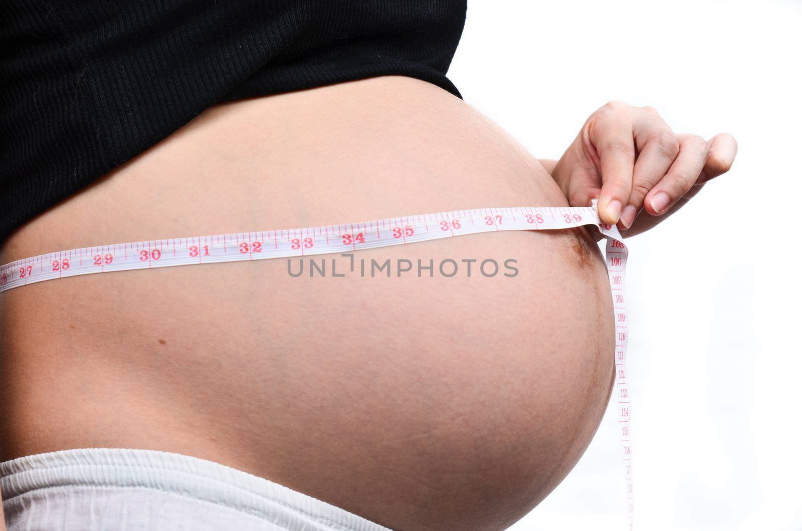 Woman holding her pregnant belly. White background.