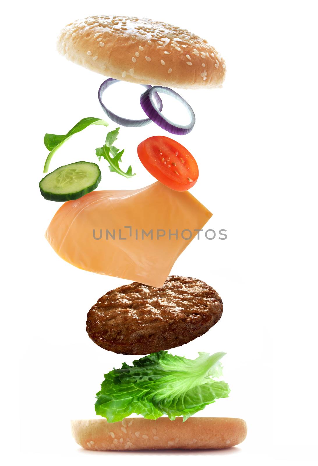 Burger ingredients falling into place to create a sandwich over a white background