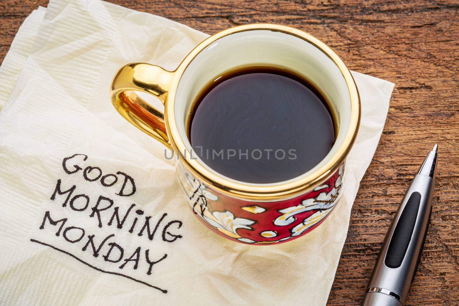 Good morning, Monday - handwriting on a napkin with a cup of coffee