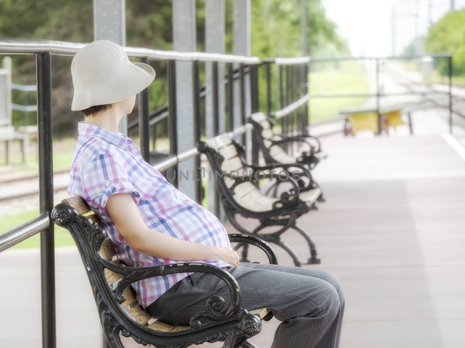 A pregnant women sitting in a train station