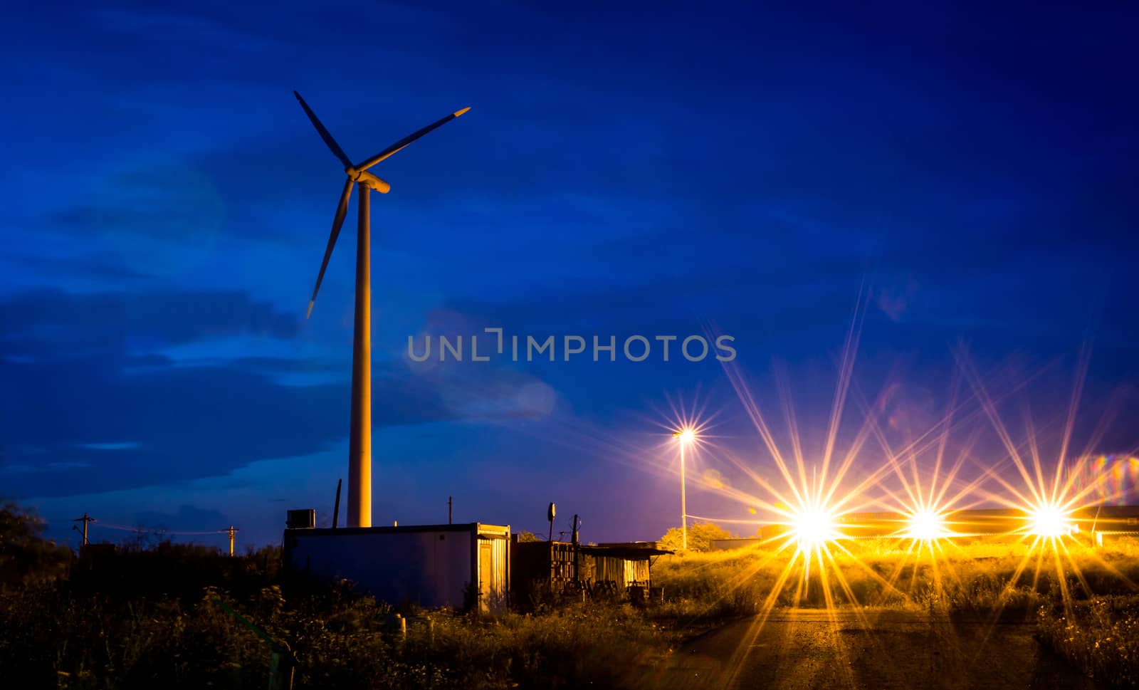 Night scene with wind propeller and lights.