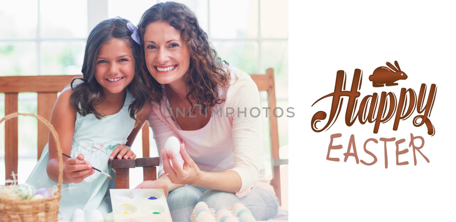 Happy mother and daughter painting easter eggs  against happy easter graphic