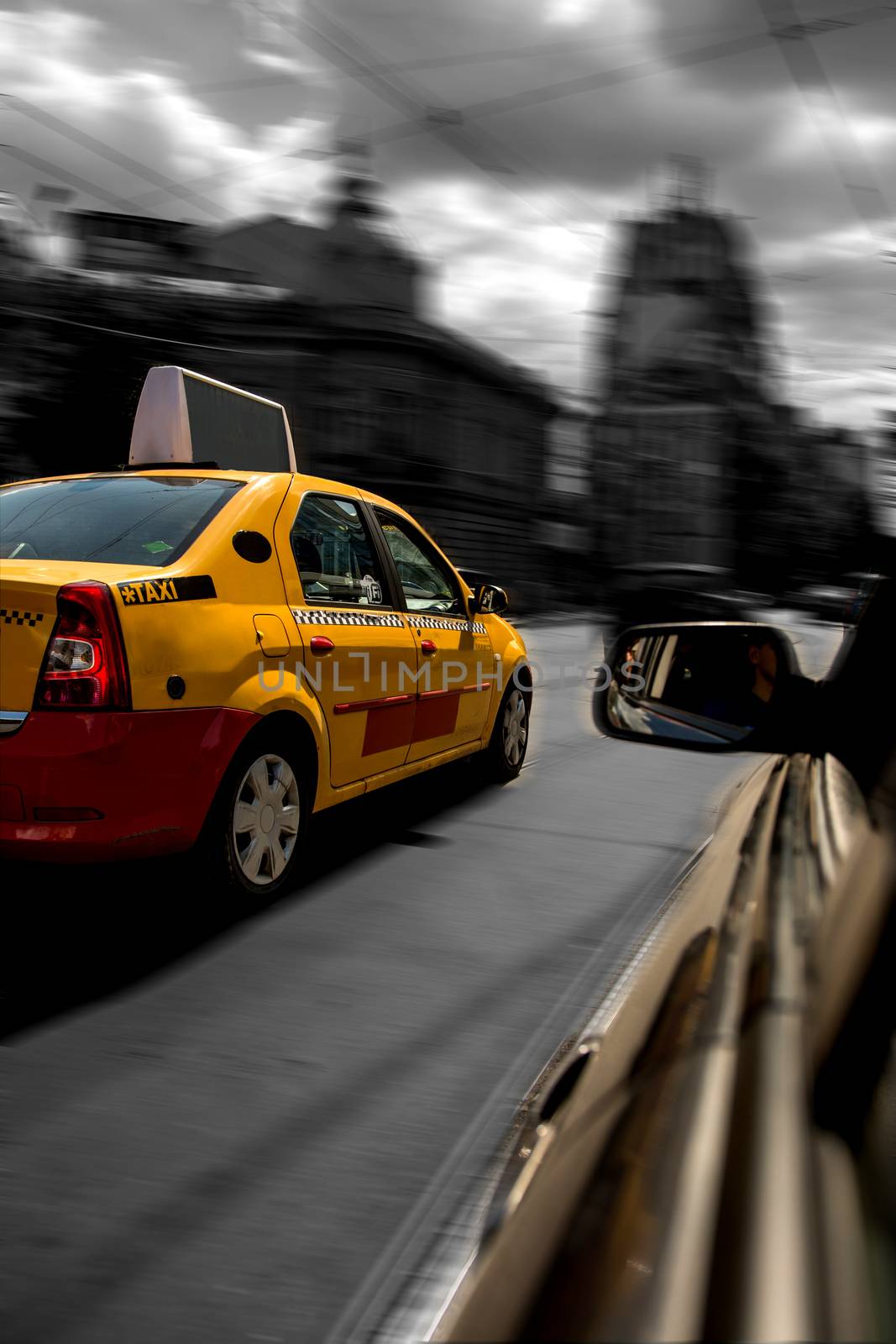 Yellow cab chased by black car in motion blur speed traffic.