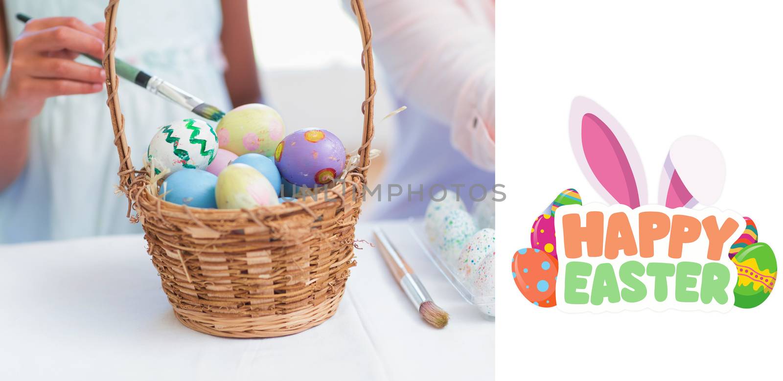 Happy mother and daughter painting easter eggs  against happy easter graphic