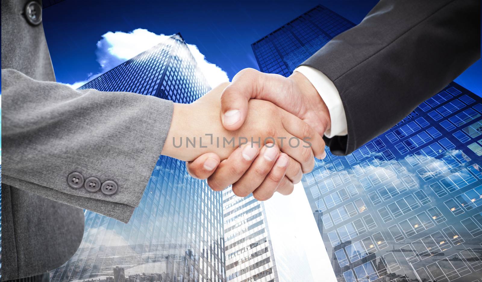 Handshake between two business people against skyscraper