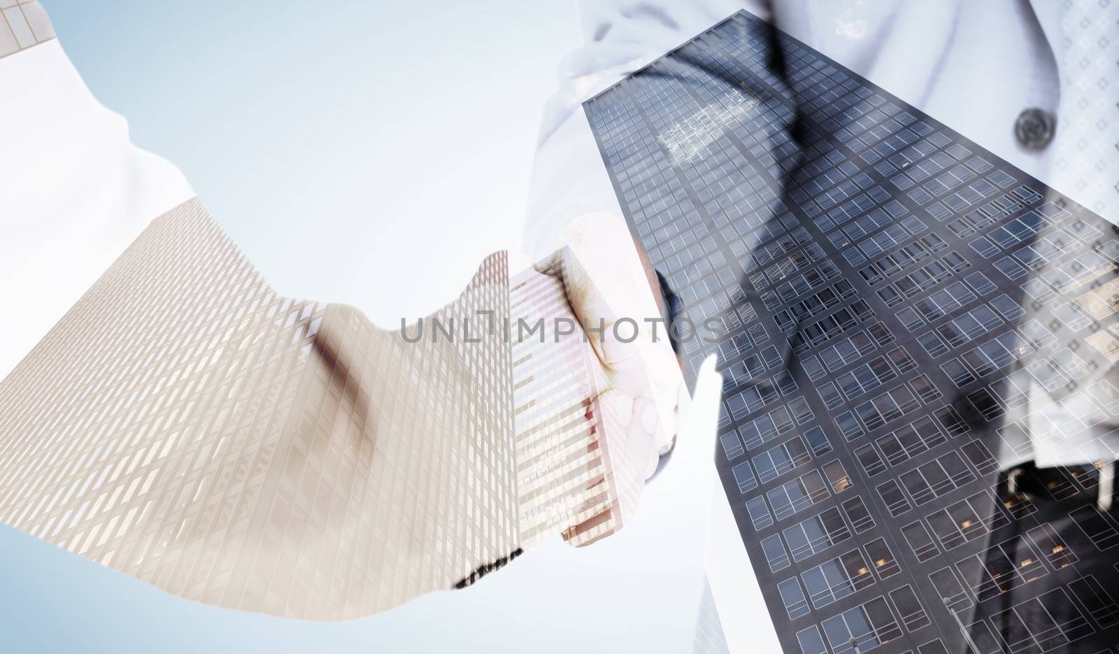 People in suit shaking hands against skyscraper