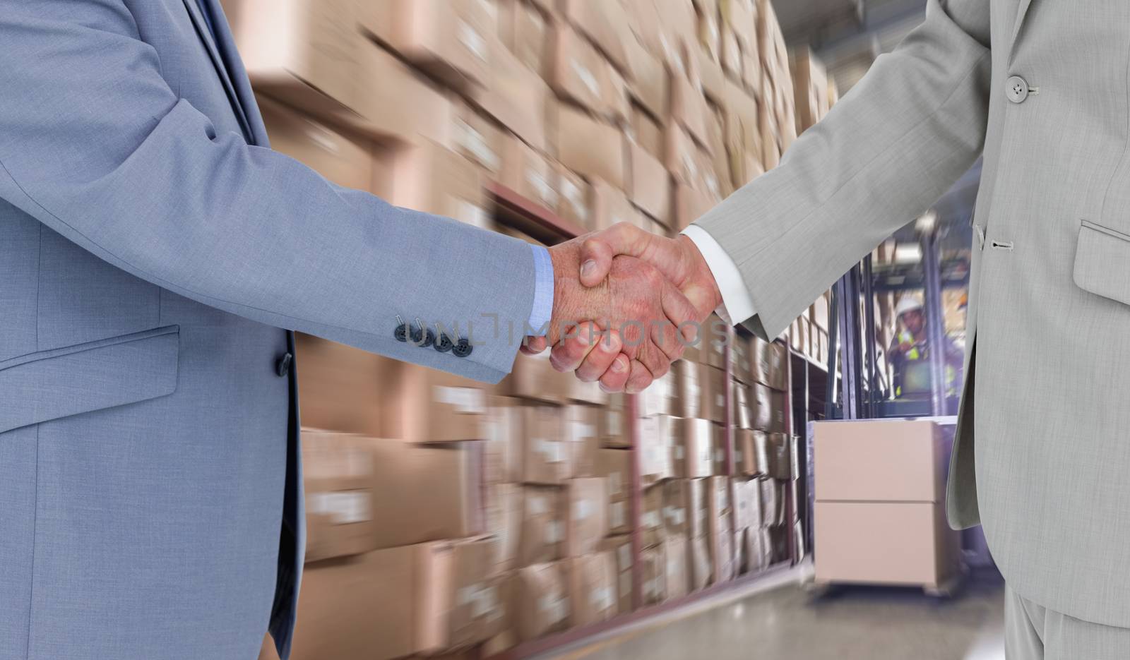 Side view of shaking hands against forklift machine in warehouse