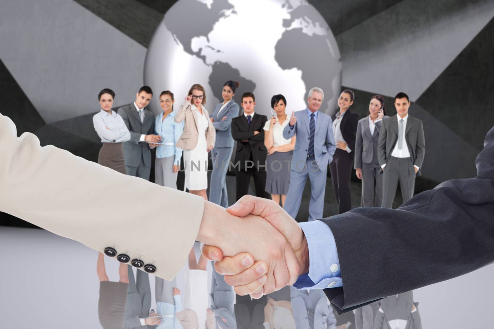 Smiling business people shaking hands while looking at the camera against planet on grey abstract background