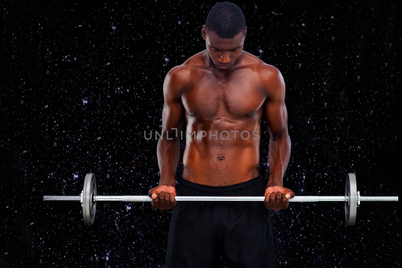 Fit man lifting barbell against black background