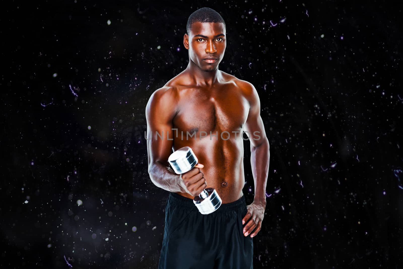 Portrait of a fit shirtless young man lifting dumbbell against black background