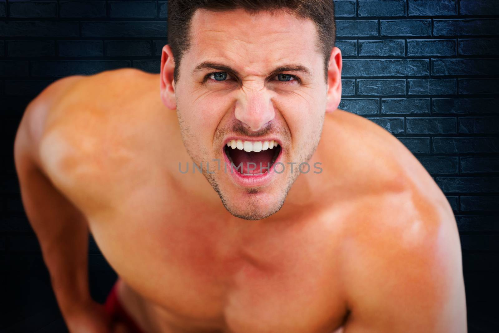 Bodybuilder shouting against black background