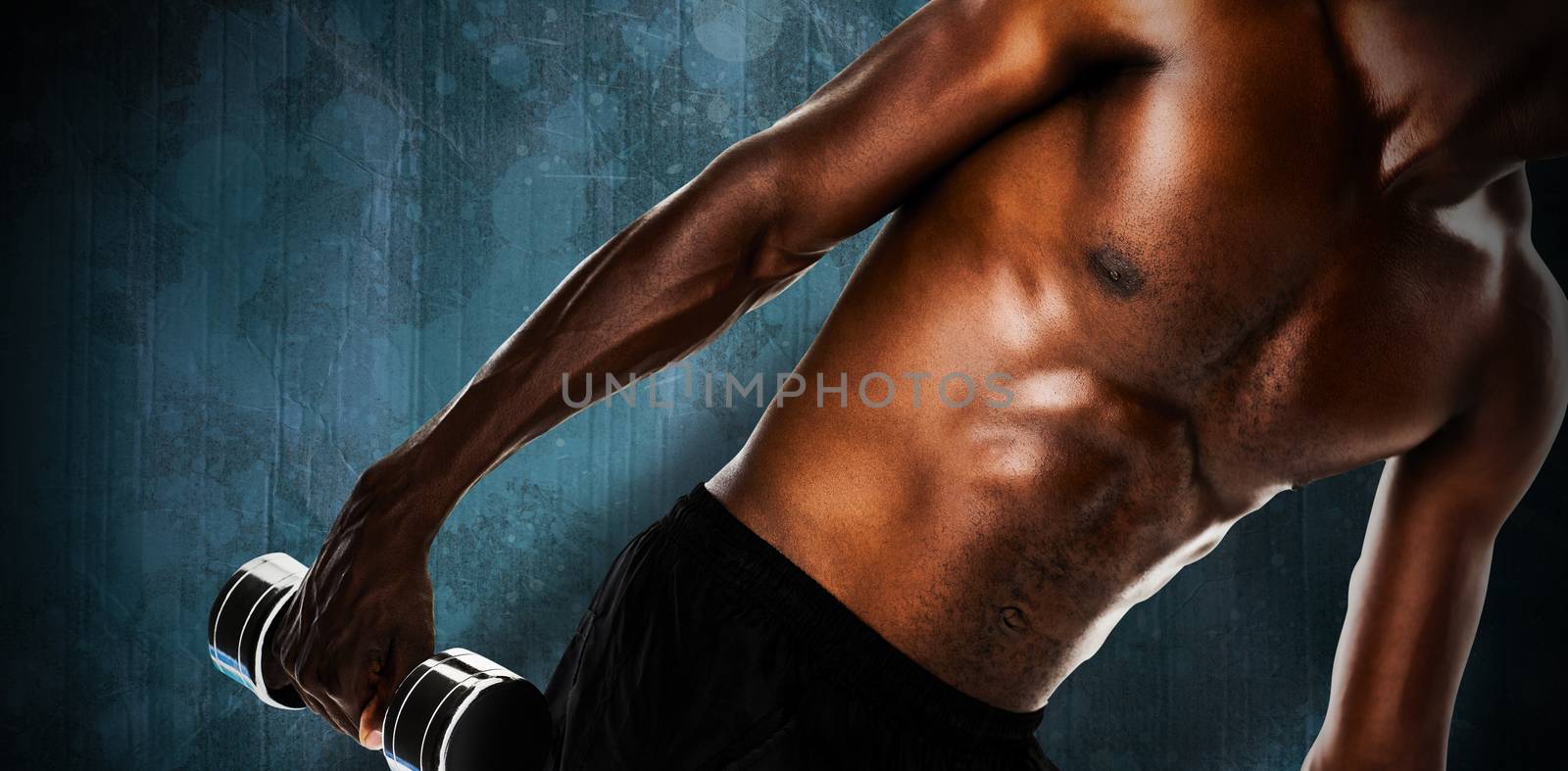 Mid section of fit shirtless young man lifting dumbbell against blue paint splashed surface