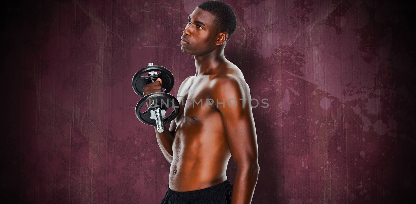 Serious fit shirtless young man lifting dumbbell against red paint splashed surface