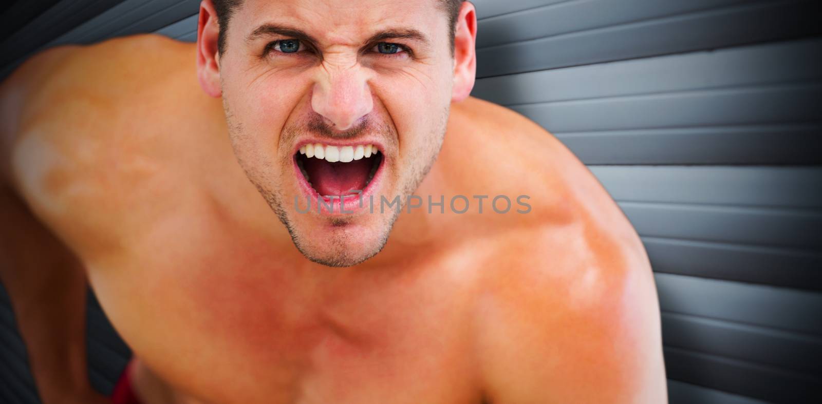 Bodybuilder shouting against grey shutters