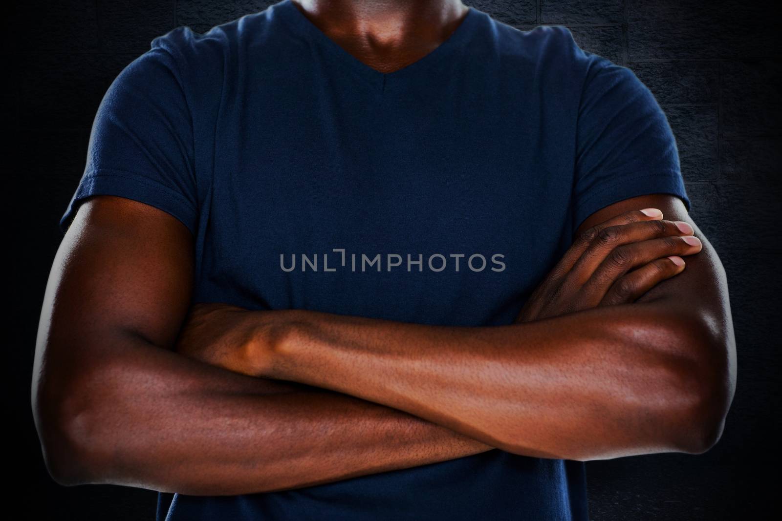 Close up mid section of man with arms crossed against black background