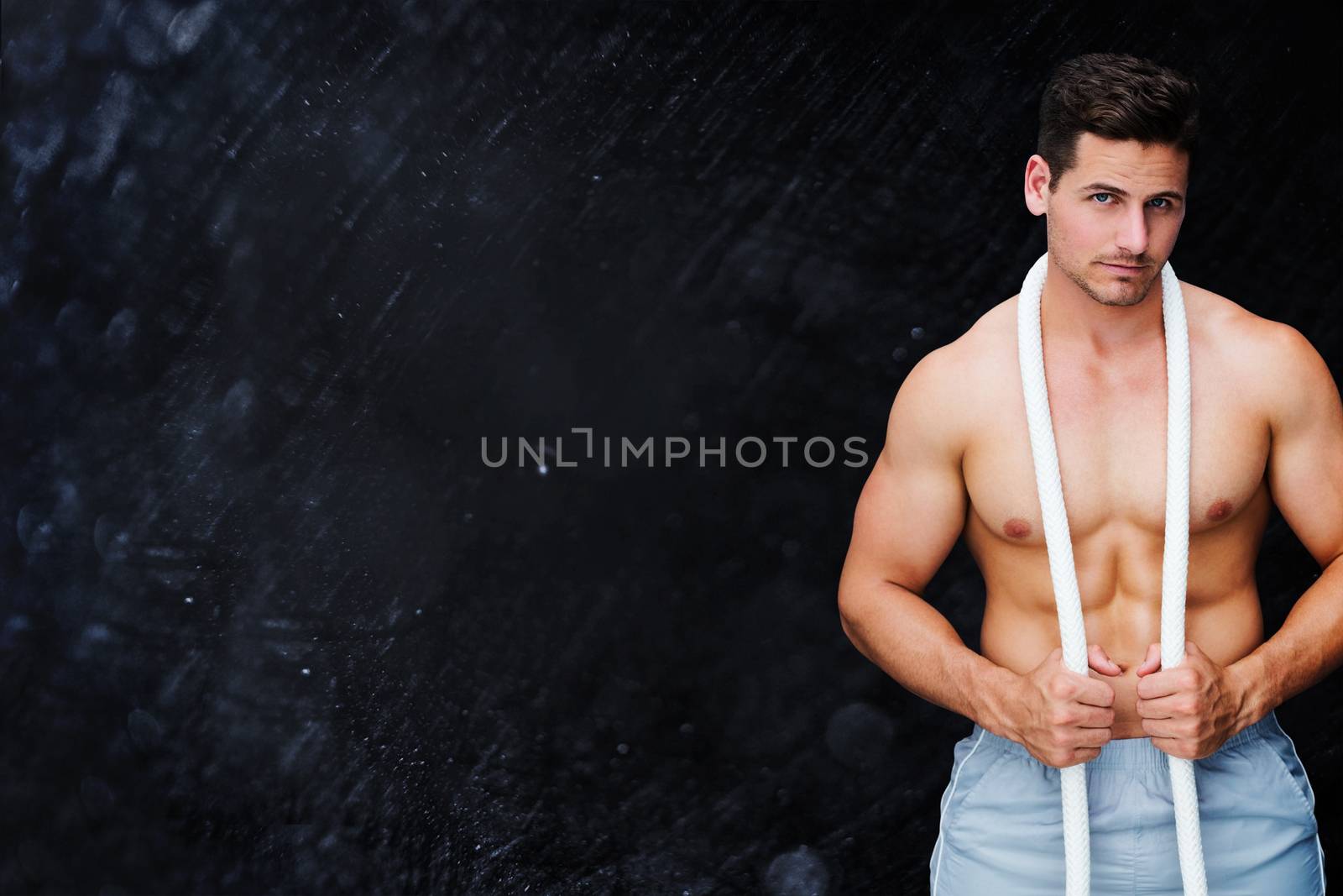 Handsome bodybuilder against black background