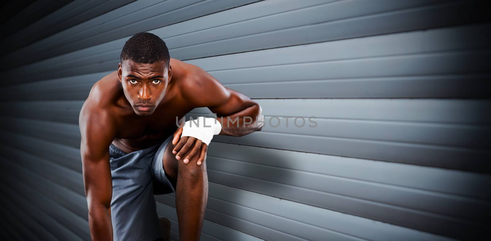 Fit muscular man against grey shutters