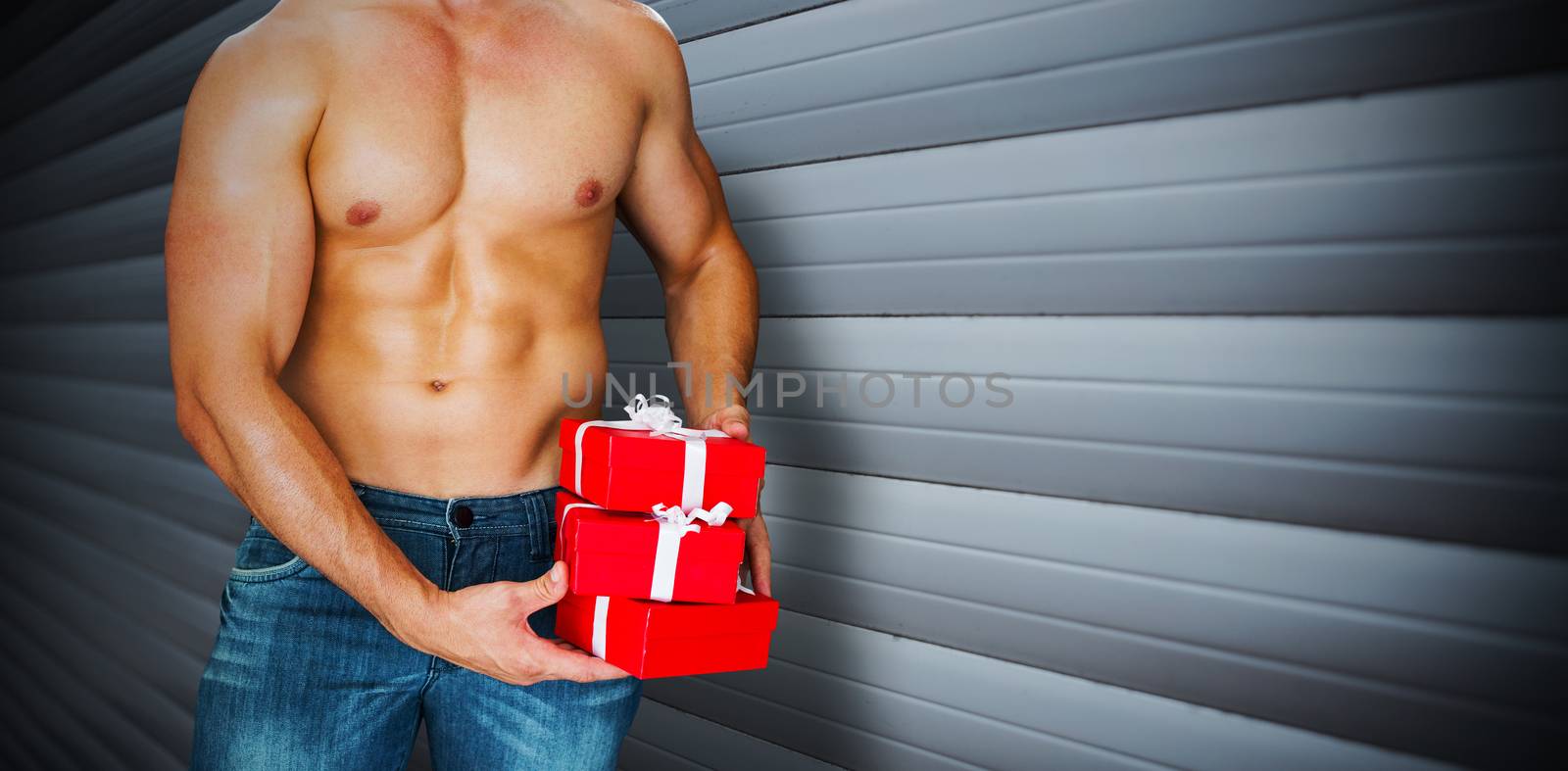 Composite image of attractive bodybuilder with gifts by Wavebreakmedia