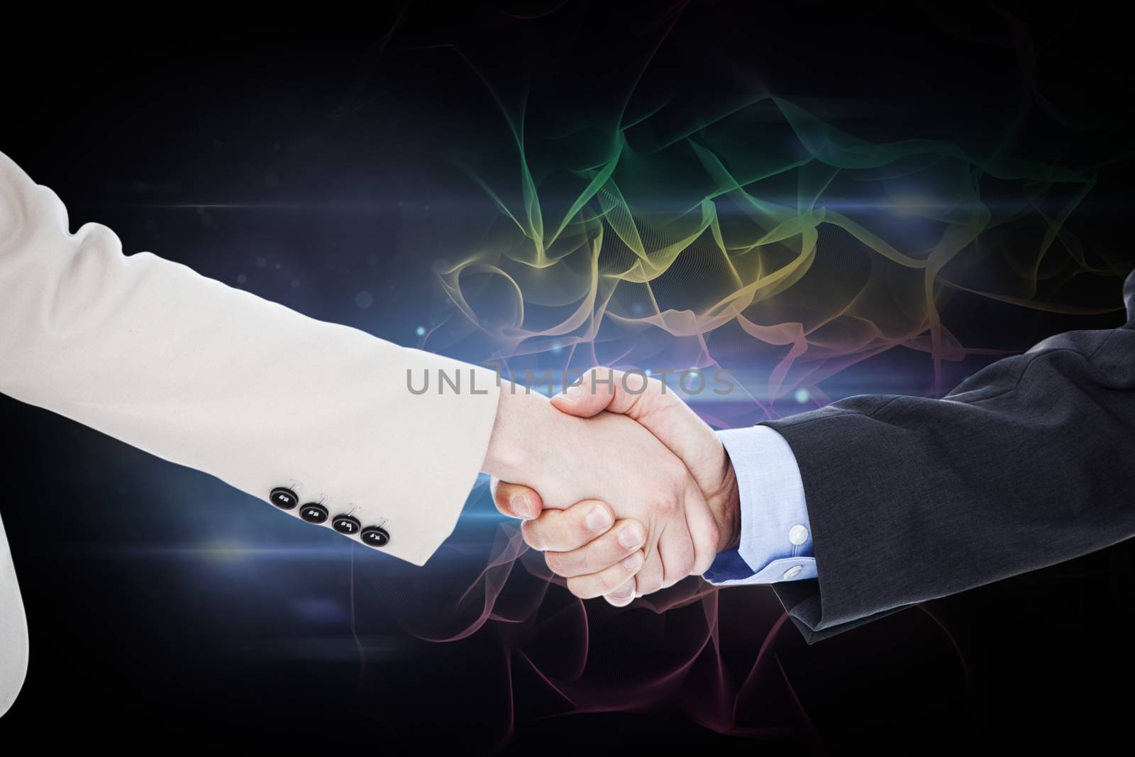 Composite image of smiling business people shaking hands while looking at the camera by Wavebreakmedia