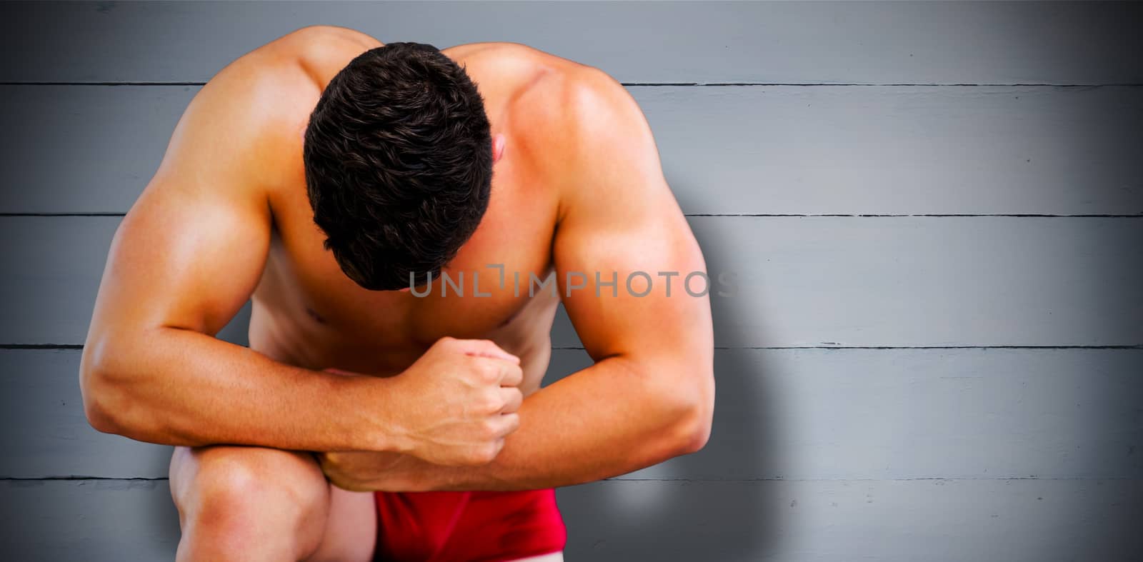 Bodybuilder posing against painted blue wooden planks