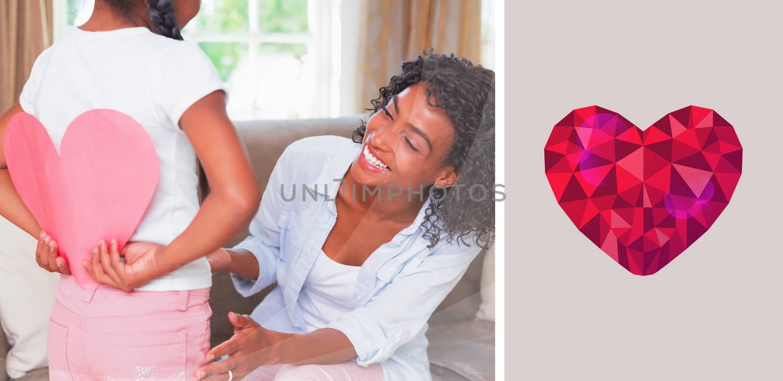 heart against pretty mother sitting on couch with daughter hiding heart card