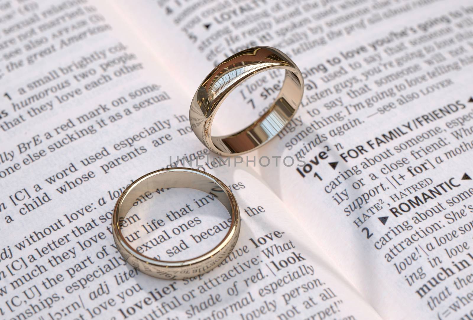 Wedding rings on a dictionary page showing love definition,  close up