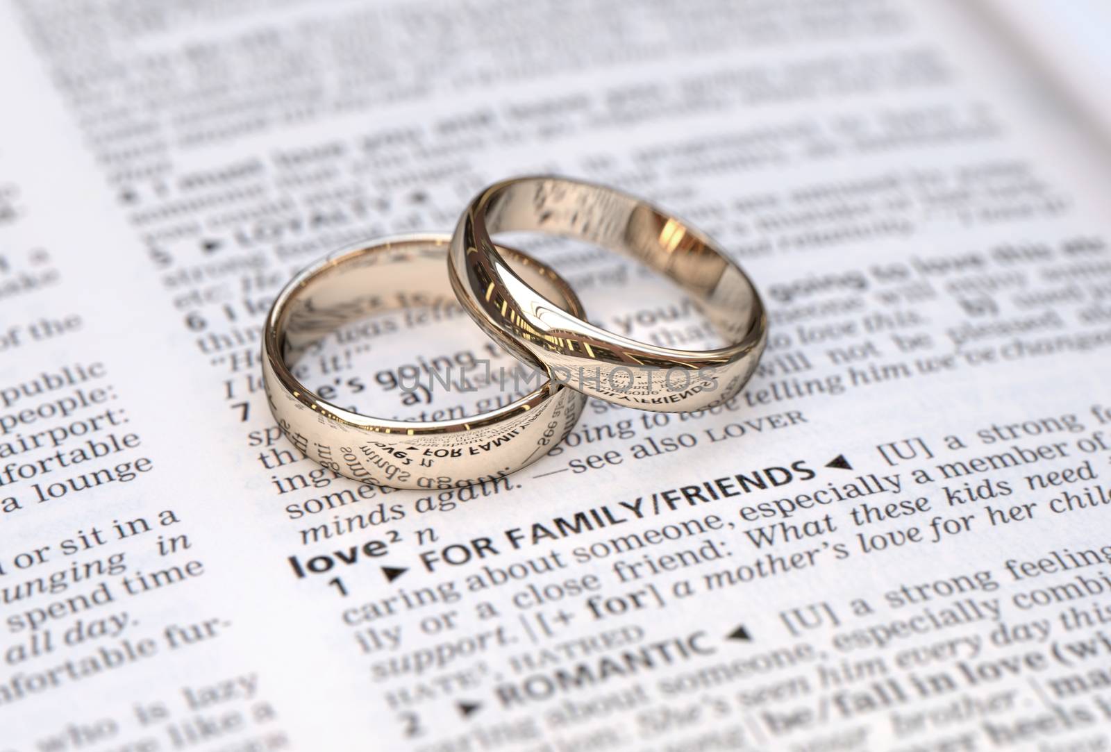 Wedding rings on a dictionary page showing love definition,  close up