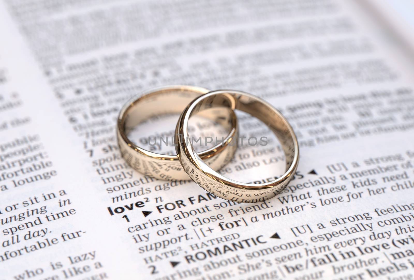 Wedding rings on a dictionary page showing love definition,  close up