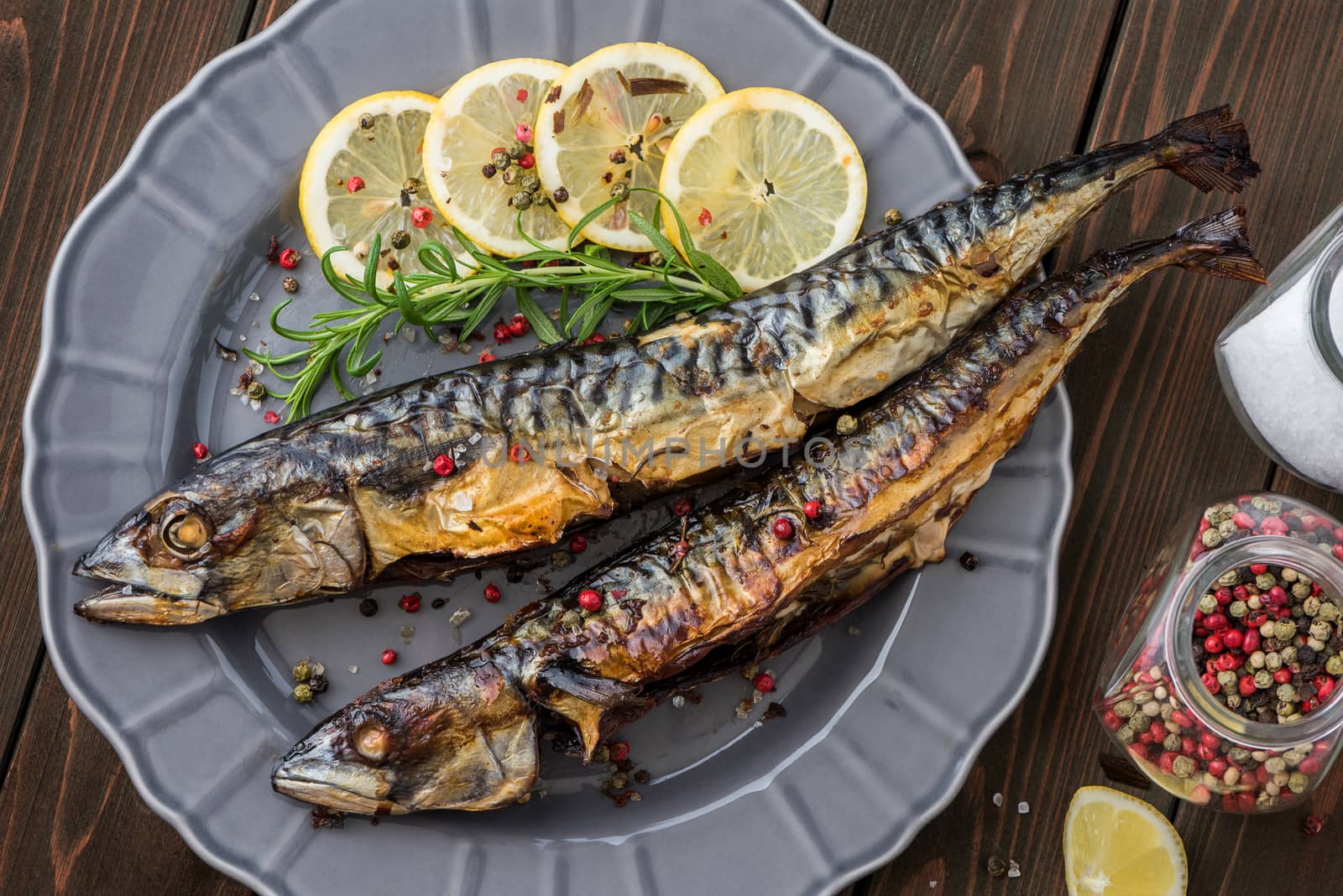 Baked Whole Mackerel Fish with Spice, Lemon and Rosemary on a Plate on Wooden Table