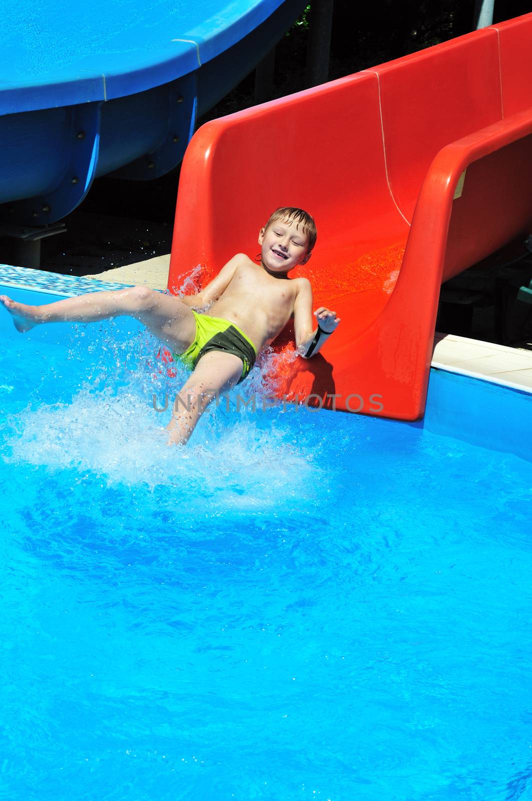 funny little boy sliding down a water slide 