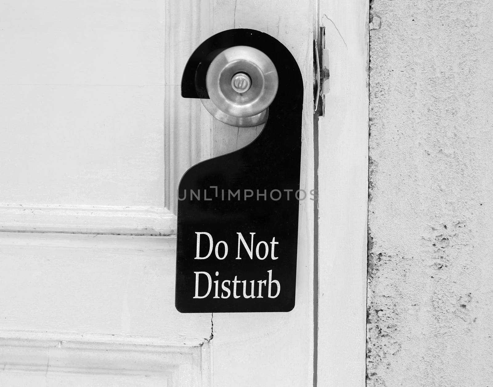 Do not disturb sign hang on door knob and stone wall.