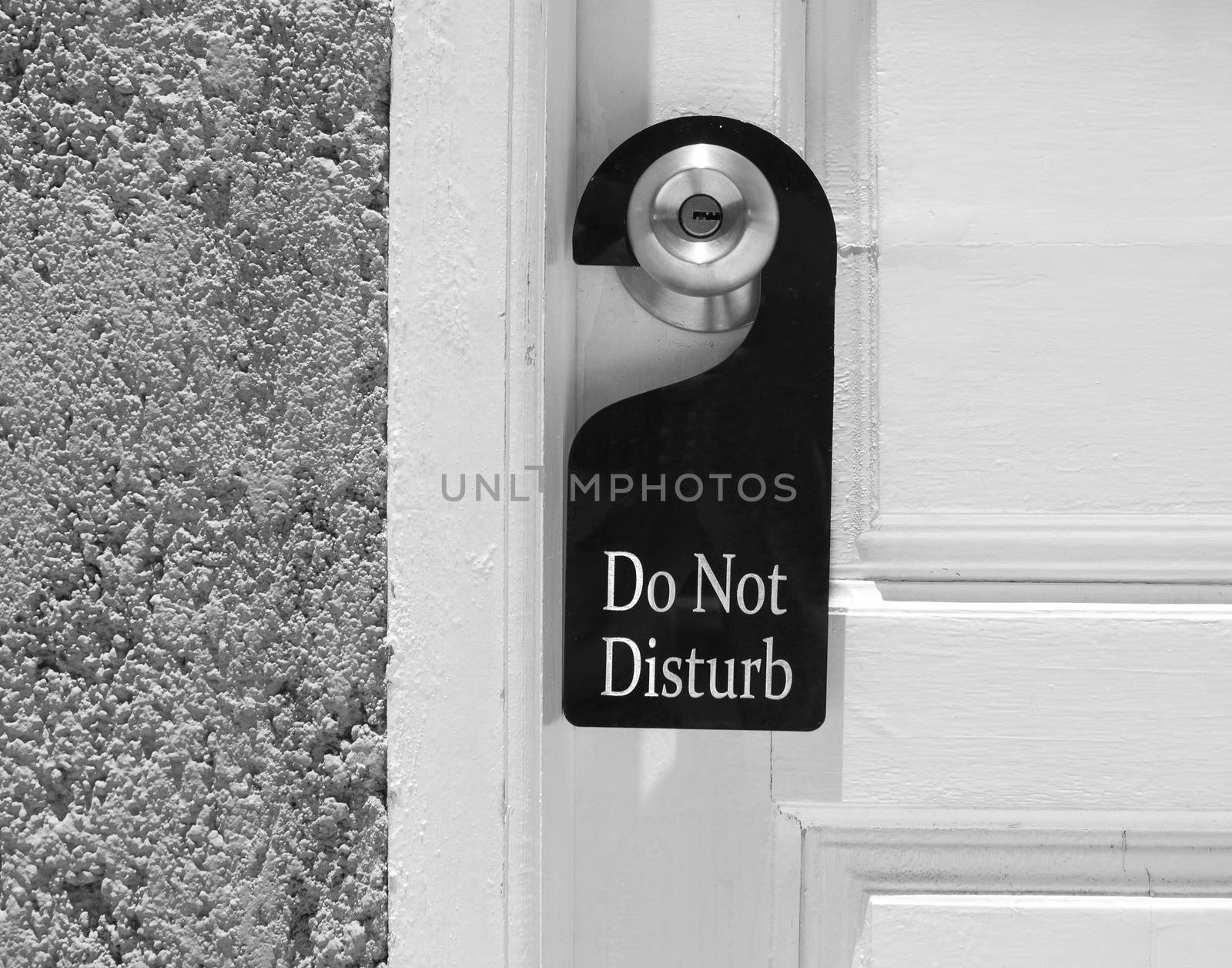 Do not disturb sign hang on door knob and stone wall.