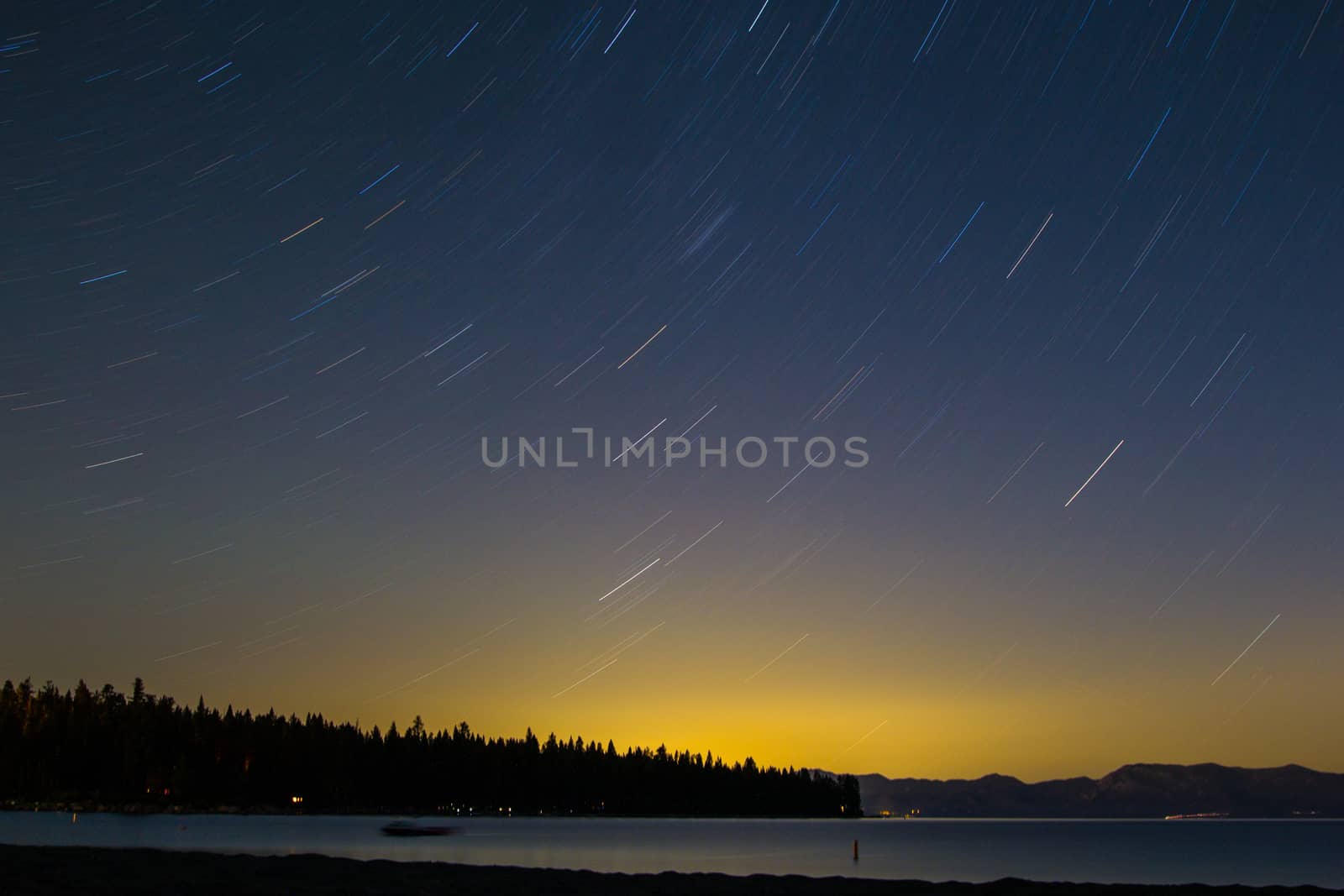 Star trails over the colors of the setting sun in Lake Tahoe, CA.