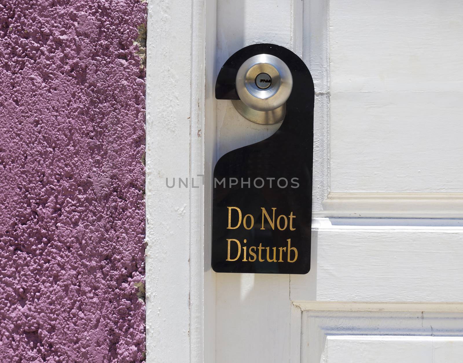 Do not disturb sign hang on door knob and stone wall.