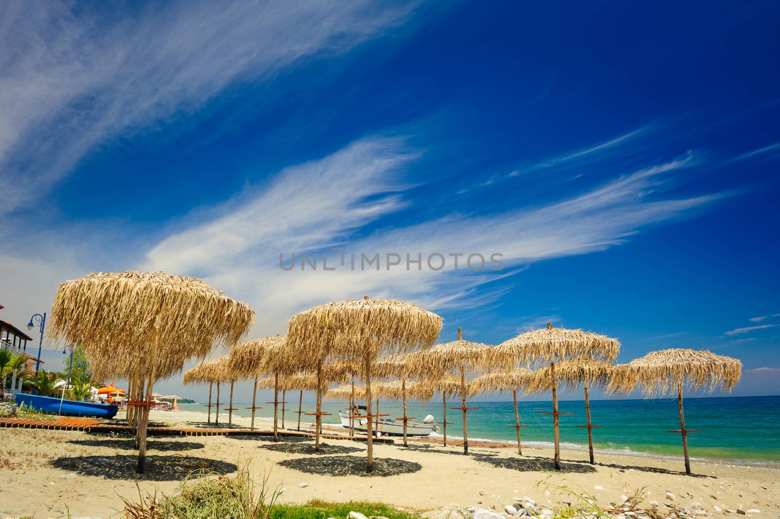 Rows of reed umbrellas on the sea beach 