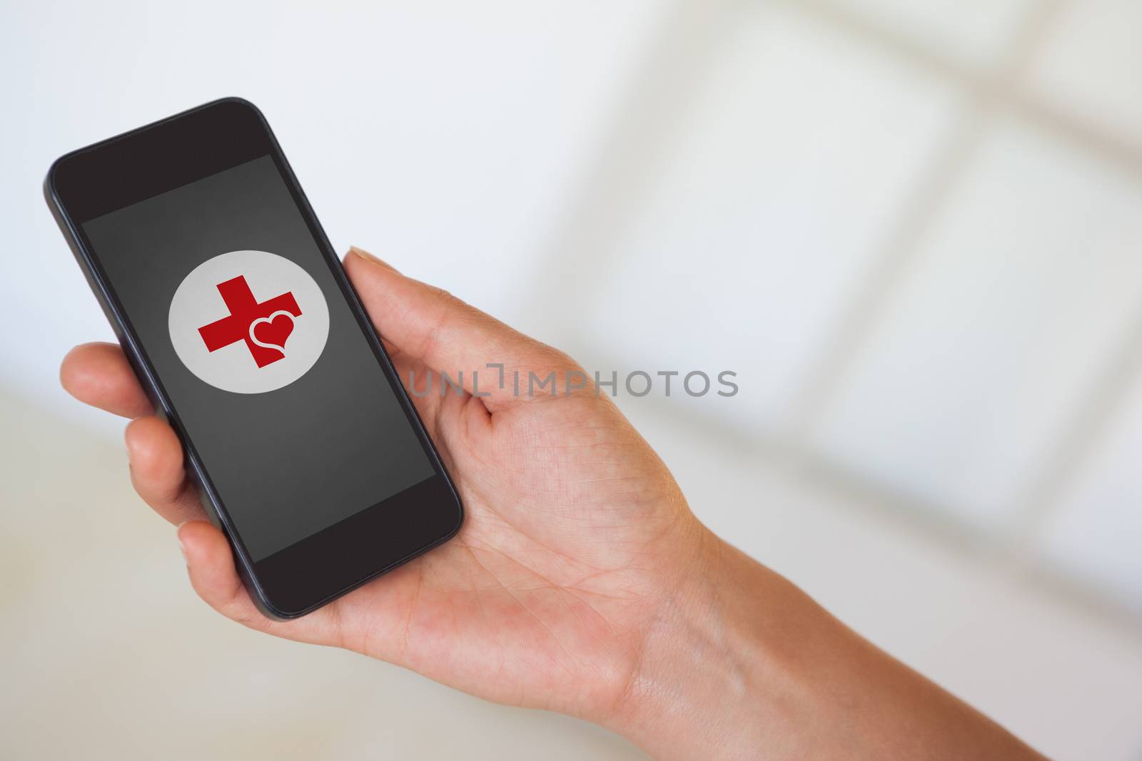 Composite image of womans hand holding black smartphone by Wavebreakmedia