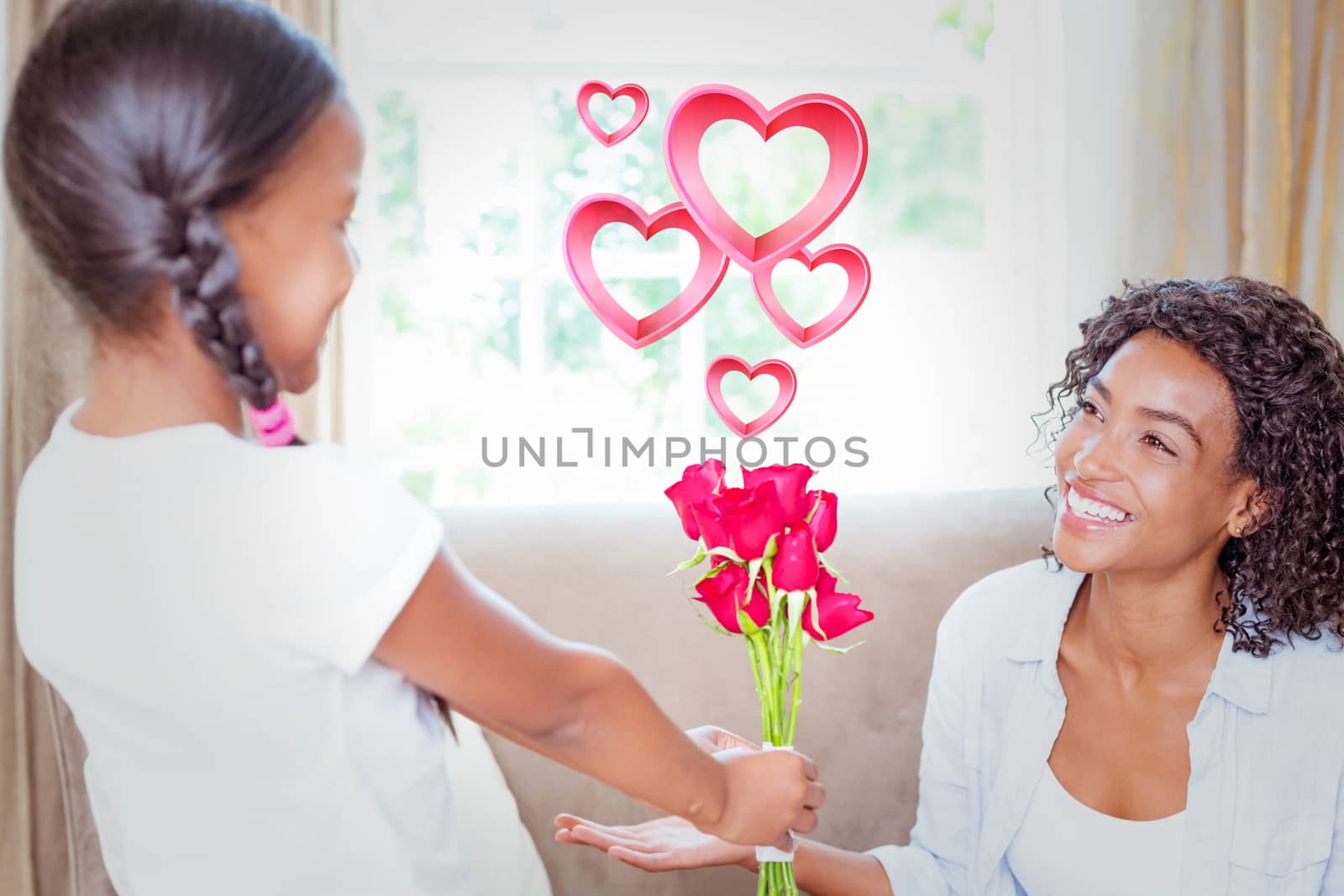 Pink hearts against pretty mother sitting on the couch with her daughter offering roses