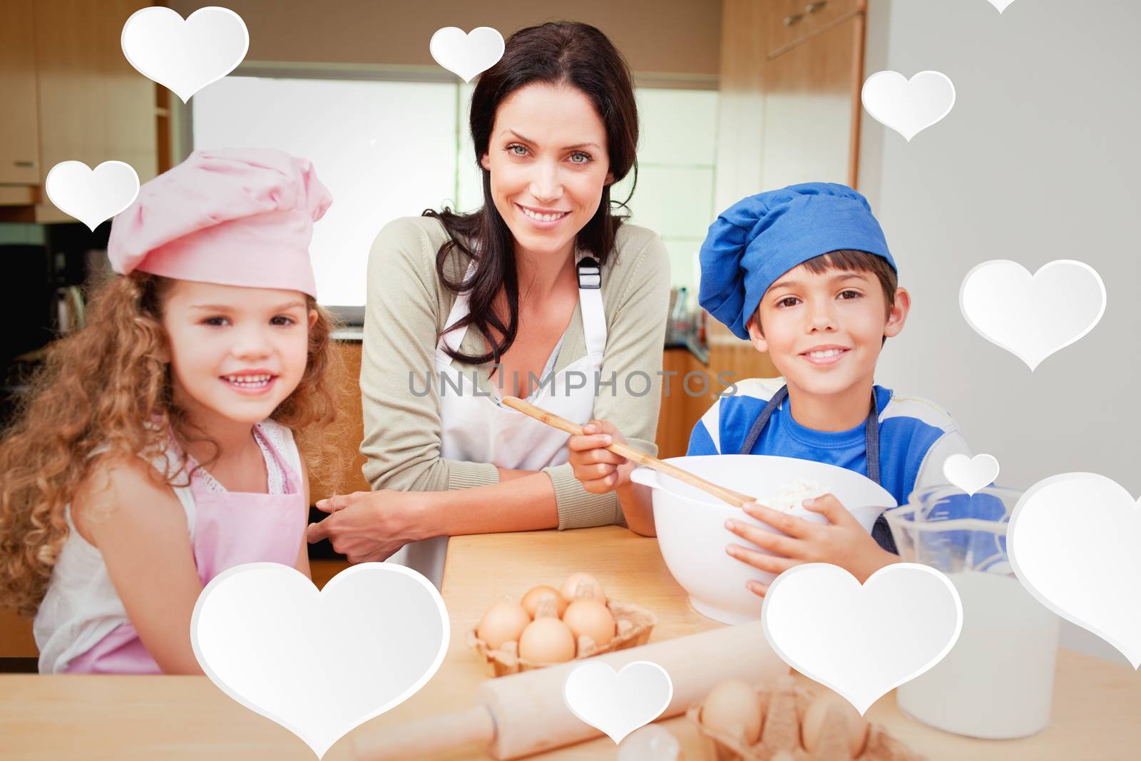 Mother and her children preparing cake against cute hearts