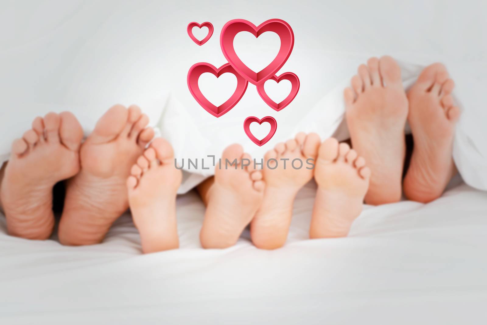 Composite image of  family on the bed at home with their feet showing by Wavebreakmedia
