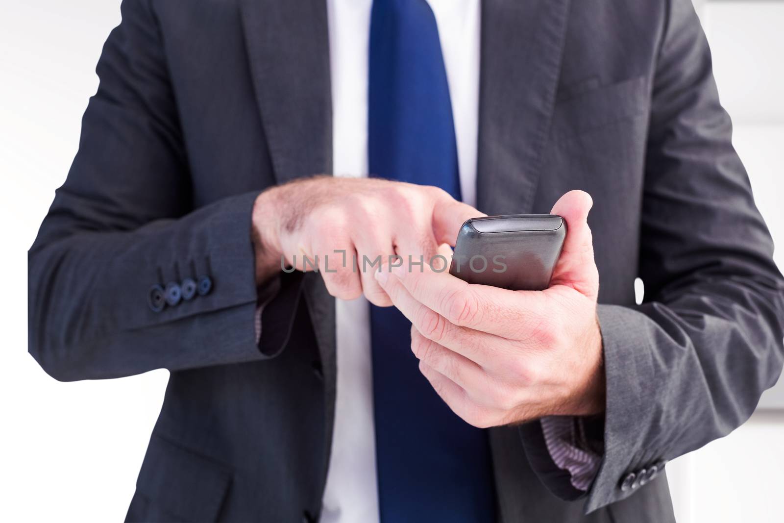 Businessman sending a text message against abstract white design